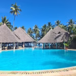 Kenya’s Coast offers idyllic beaches, crystal-clear waters, and rich Swahili culture. From the vibrant city of Mombasa to serene islands like Lamu, it’s a paradise of sun, sea, and history waiting to be explored. Kenya’s Coast is a tropical paradise where white sandy beaches meet crystal-clear turquoise waters, backed by rich cultural heritage and vibrant Swahili traditions. Stretching from the bustling port city of Mombasa to the serene islands of Lamu and Watamu, the coast offers something for every traveler. Mombasa’s Old Town, with its narrow alleys, historic Fort Jesus, and colorful markets, provides a glimpse into the region’s diverse past shaped by Arab, Portuguese, and British influences. Beyond the cities, Kenya’s coastal waters teem with marine life, making it a top destination for snorkeling and diving, especially in protected areas like Watamu Marine Park. The palm-fringed beaches, warm waters, and colorful coral reefs are perfect for water sports, while dhow cruises and island hopping offer unique ways to explore the coastline. Diani Beach, known for its powdery sands and laid-back vibe, is a favorite among travelers looking to unwind or enjoy thrilling adventures like kite surfing and jet skiing. The coastal region is also deeply rooted in Swahili culture, where visitors can experience local cuisine, music, and traditional crafts. From exploring ancient ruins like Gede to savoring fresh seafood and spicy Swahili dishes, the Kenyan Coast is a sensory journey through history, relaxation, and adventure. Whether you’re looking to explore lively markets, relax on sun-soaked beaches, or dive into a world of marine wonders, the Kenyan Coast offers an unforgettable experience steeped in natural beauty and cultural richness.
